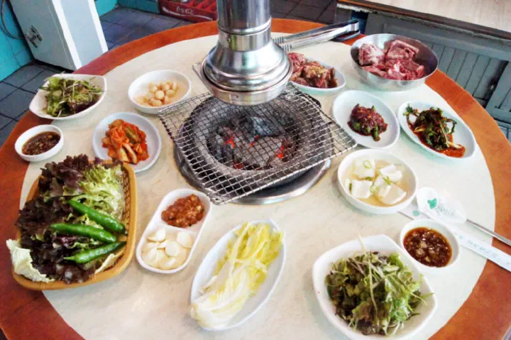 Korean side dishes laid out before the beef