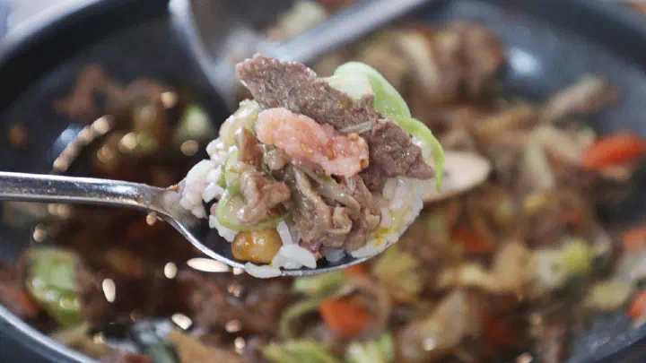 A serving of bulgogi with glass noodles and vegetables on a small plate