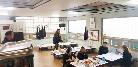 Renovated dining room at Jeonsan Garden with tables and chairs and local diners at lunch