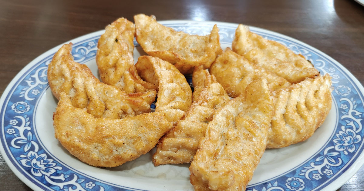 Plate of fried dumplings with garlic cucumber side at Geumyong Mandu, Gupo