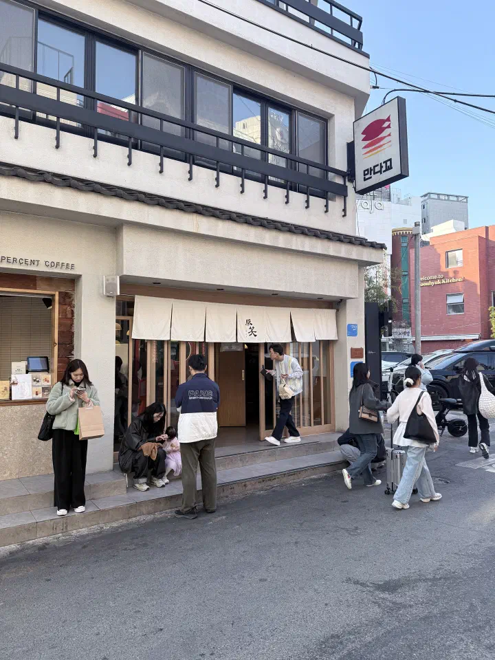 Exterior of Tonshou Gwangan tonkatsu restaurant in Gwangalli, Busan, with customers waiting outside