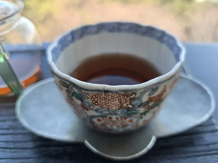 Aged hwangcha served in an antique porcelain teacup by the window at Bibibidang