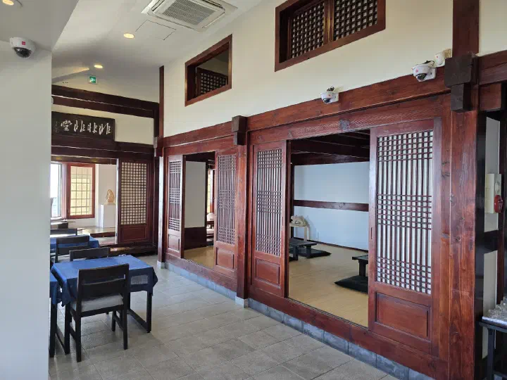 Hanok-style tea room at Bibibidang with raised floor seating and regular tables