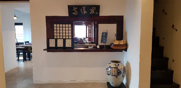 Order counter at Bibibidang tea house with a fish-painted ceramic jar beside it