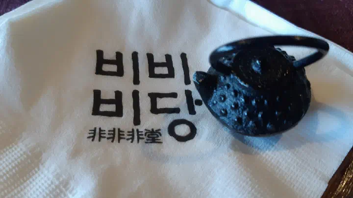 Bibibidang napkin printed with the tea house logo next to a cast-iron teapot
