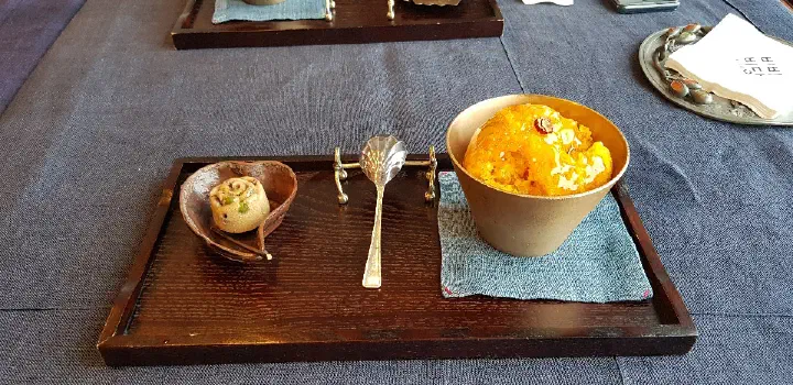 Sweet pumpkin shaved ice served in a brass bowl on a wooden tea tray at Bibibidang