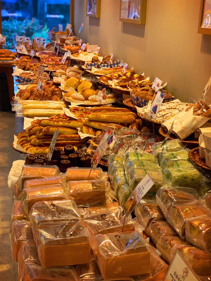 Bread shelves inside OPS Haeundae bakery with individually wrapped castella and matcha roll cakes