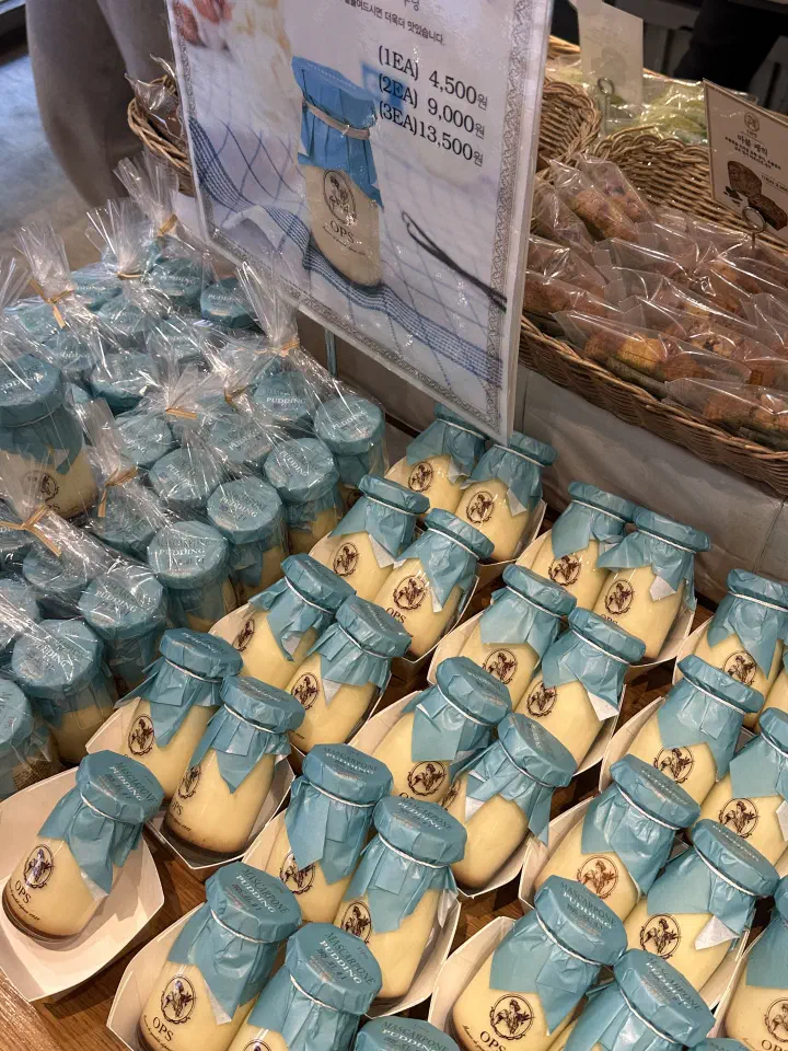 OPS mascarpone pudding in glass jars with pale blue paper lids stacked on the counter