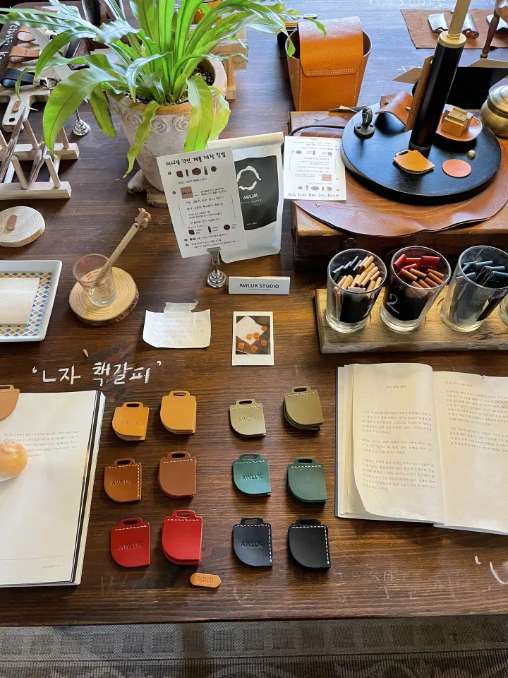 Handmade leather bookmarks in assorted colors and the initial-engraving tools at Awluk Studio
