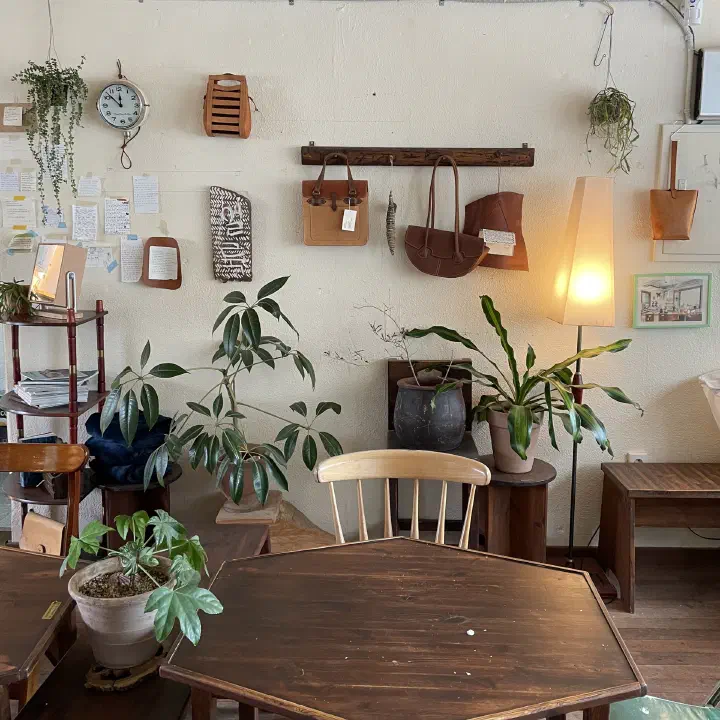 Handmade leather bags hanging on the wall at Awluk, surrounded by guestbook notes left by customers