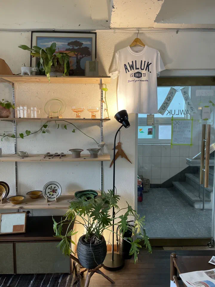 Staircase leading to the second-floor entrance of Awluk cafe in Jeonpo, Busan, with the AWLUK logo on the glass door