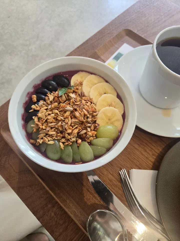 Acai bowl with granola and fruit served with a cup of Today&rsquo;s Hand Drip coffee at Momos Coffee