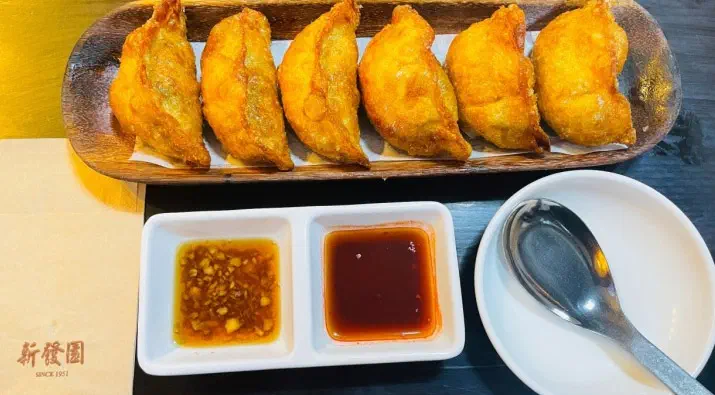 Plate of fried dumplings at Sinbalwon served with two dipping sauces, garlic soy and chili vinegar