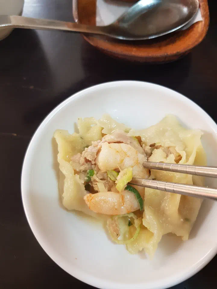 Sinbalwon shrimp dumpling opened up to show the whole shrimp and pork filling inside