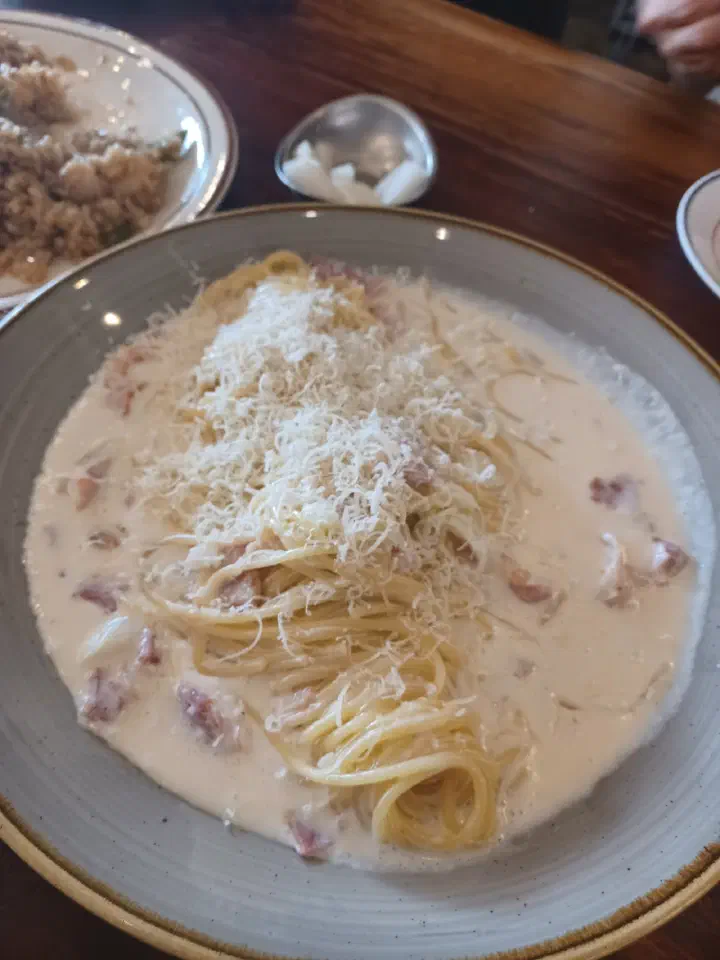 Bacon cream spaghetti at Cheongchun Kitchen, a rich cream pasta finished with grated cheese