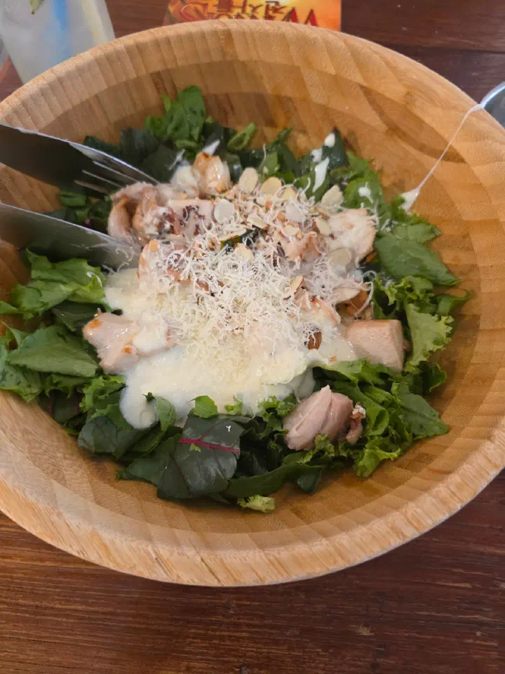 Cheongchun Kitchen&rsquo;s signature salad in a wooden bowl with chicken, nuts and freshly grated cheese