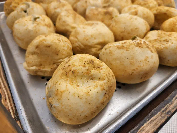 Freshly baked original potato bread on a tray at Gamzabatt in Chuncheon