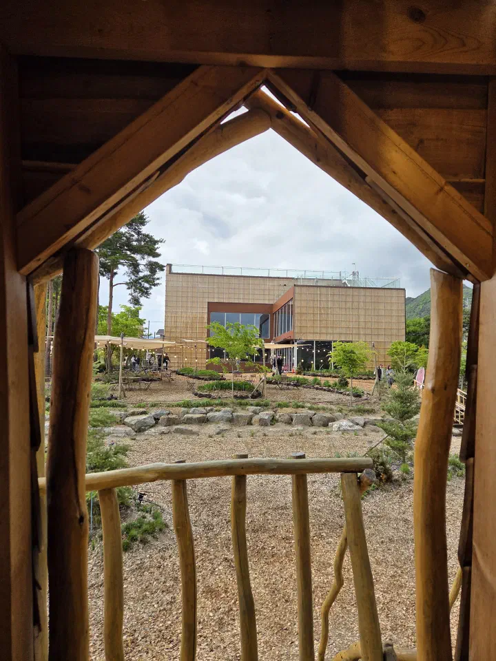 View of the new Gamzabatt building from the wooden hut photo spot in the garden