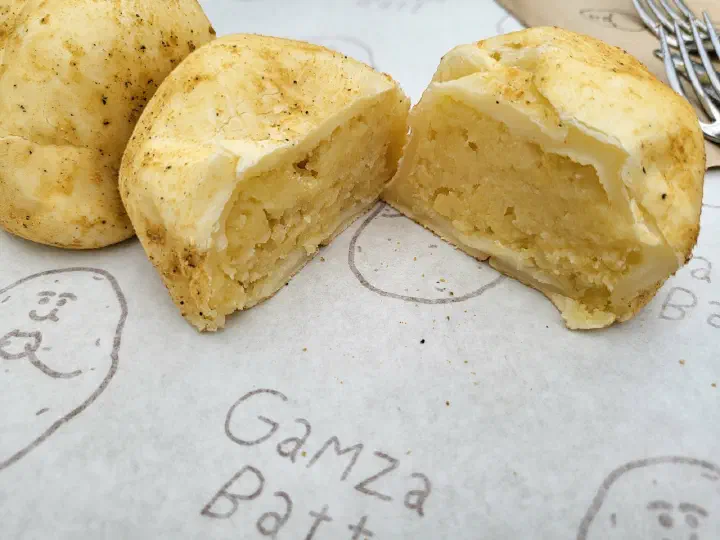 Gamzabatt potato bread torn open to show the smooth potato filling inside