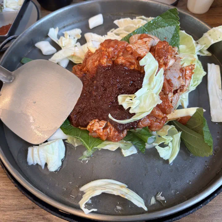 통나무집닭갈비 본점의 뼈를 발라낸 닭목살과 양념장, 깻잎이 올라간 철판