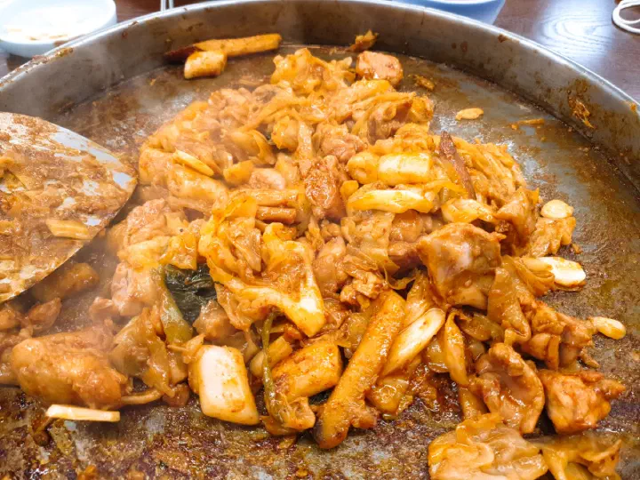 춘천 통나무집닭갈비 본점의 철판에서 완성된 닭갈비와 떡, 양배추