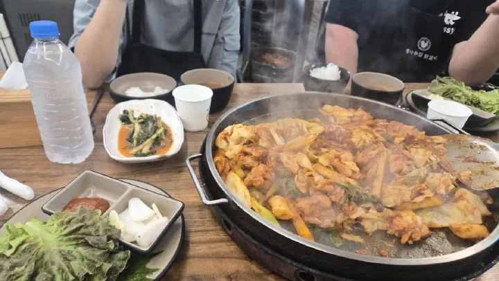 통나무집닭갈비 본점 테이블에 차려진 철판 닭갈비와 열무김치, 쌈채소 기본 반찬