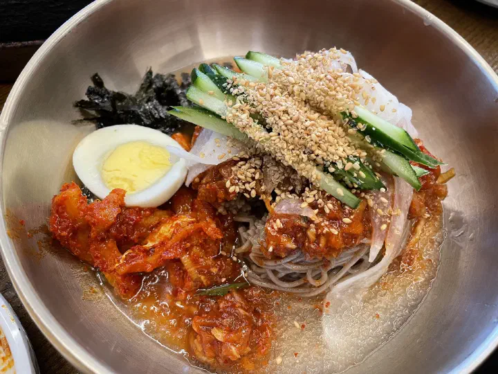 통나무집닭갈비 본점의 막국수, 메밀면 위에 삶은 달걀과 오이 김가루 깨