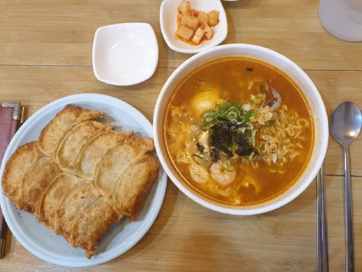 Taesan Mandu a meal of gunmandu dumplings paired with a bowl of spicy seafood ramyeon
