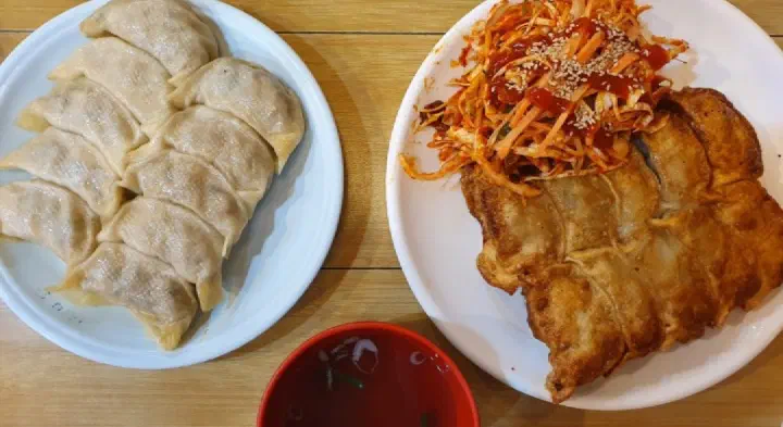 Taesan Mandu steamed dumplings and bibim-gunmandu served together on the table