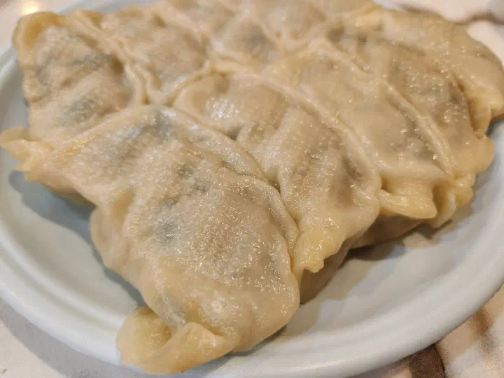 Taesan Mandu close-up of steamed dumplings, the filling showing through the translucent wrapper