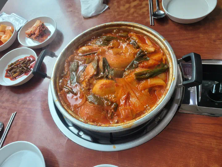 Dak-bokkeumtang bubbling in its red broth on a tabletop burner at Hanyeong Sikdang