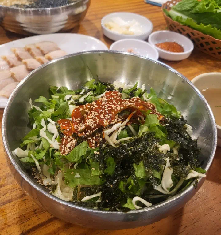 양배추와 상추, 김가루가 수북하게 올라간 김화칼국수 비빔국수