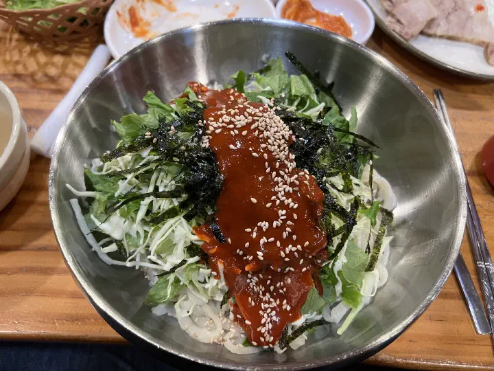 Close-up of the bright red sesame-oil chili sauce on Kimhwa Kalguksu bibimguksu