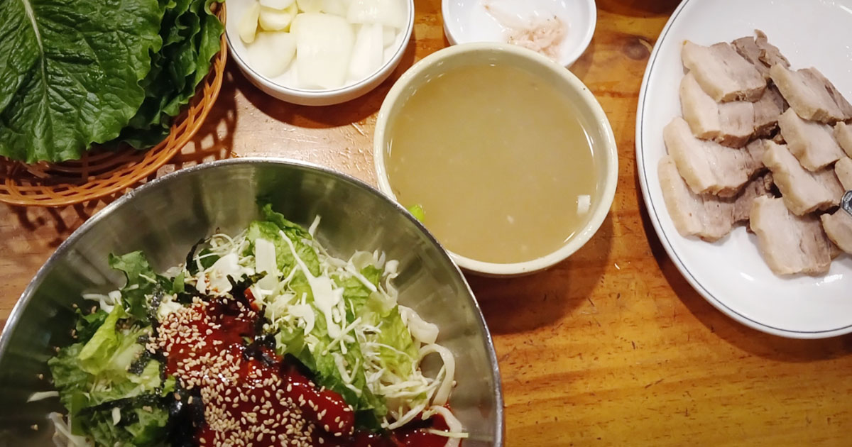 A bowl of perilla kalguksu and a plate of suyuk at Kimhwa Kalguksu