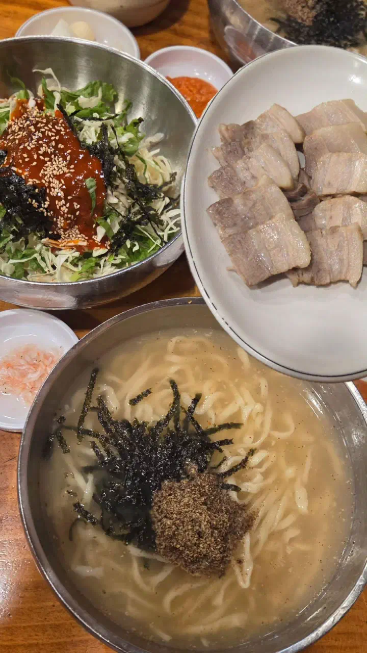 Kalguksu, bibimguksu and a plate of suyuk set out for an early meal at Kimhwa Kalguksu