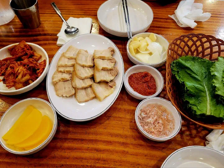 Suyuk spread at Kimhwa Kalguksu with kimchi, pickled radish, garlic, salted shrimp and lettuce