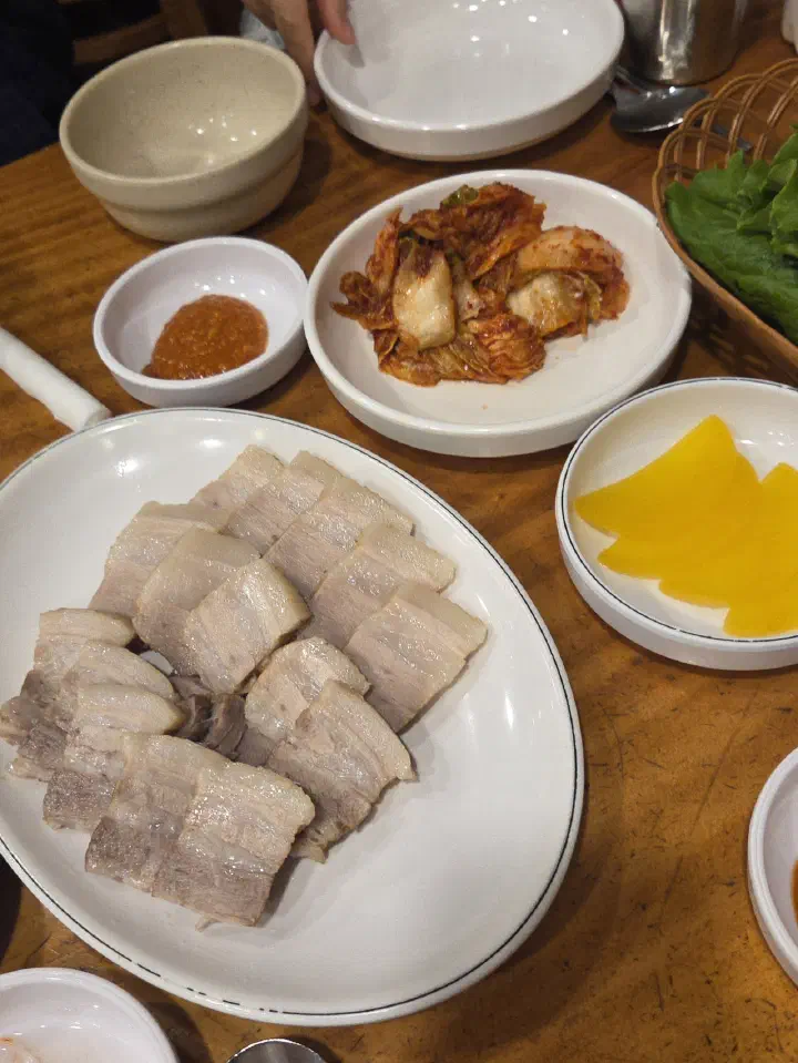 Plate of suyuk served with spicy fresh kimchi and pickled yellow radish