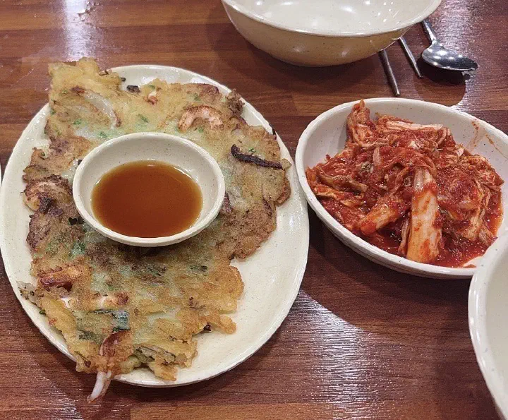 OC Kalguksu haemul-pajeon seafood and scallion pancake served with a side of spicy kimchi
