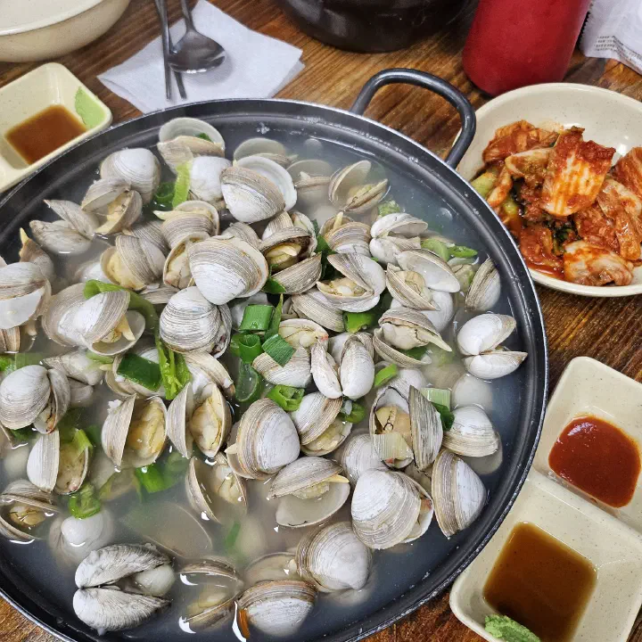 OC Kalguksu mulchong clam pot packed with dongjuk clams, served with vinegared gochujang and wasabi-soy