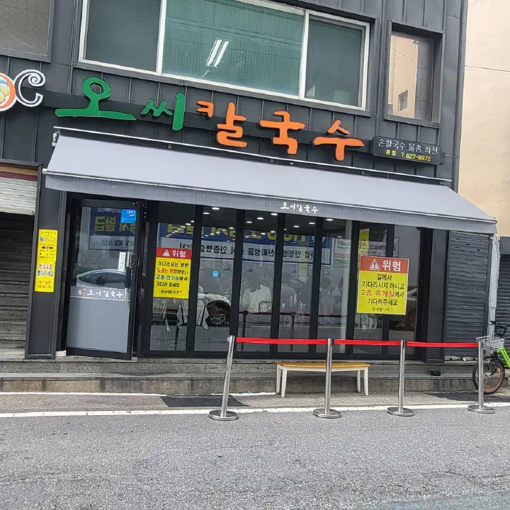 Storefront and sign of OC Kalguksu main branch in Daejeon, with notices directing guests to the second-floor waiting room