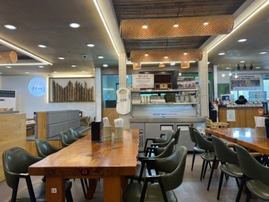 Spacious, tidy dining hall with wooden tables at Hansangeun Daetongbapjip