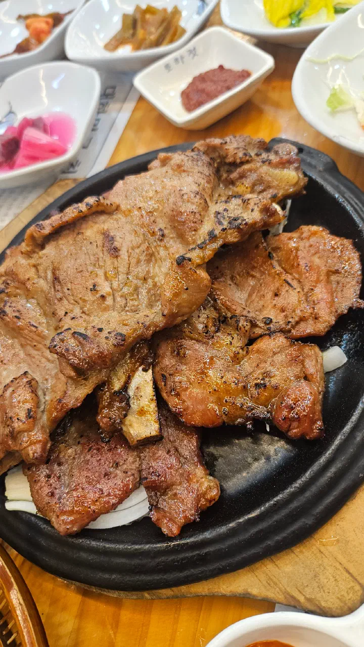 Charcoal-grilled pork ribs sizzling on the hot plate at Hansangeun Daetongbapjip