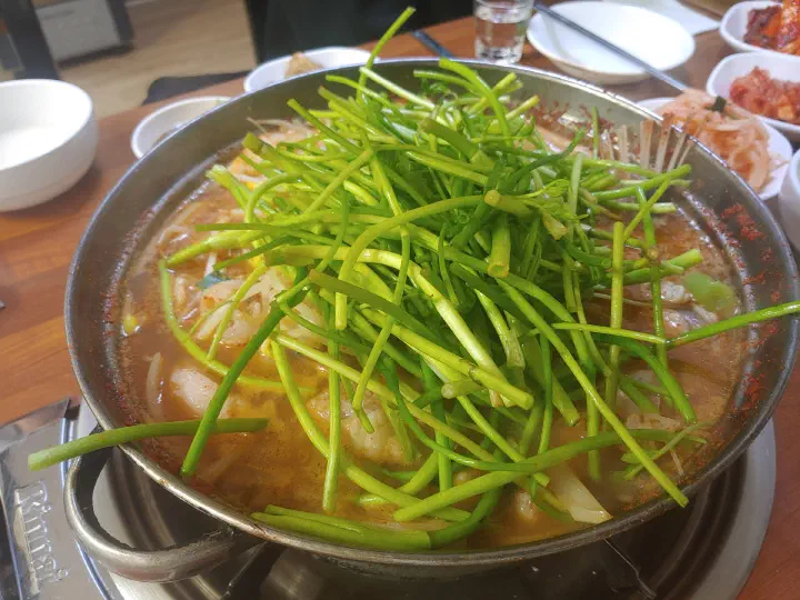 Fresh water dropwort (minari) piled over boiling monkfish stew at Samdado