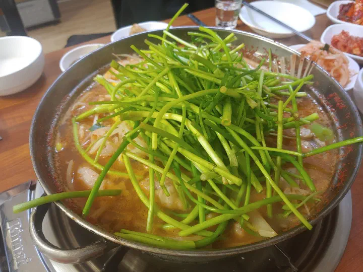 끓는 삼다도 아구탕 위에 미나리를 수북하게 얹은 모습