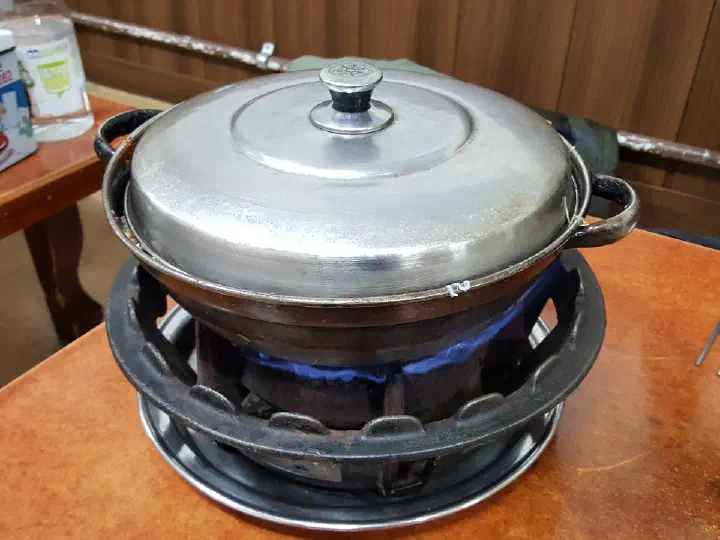 Covered monkfish stew pot simmering over a gas burner at Samdado