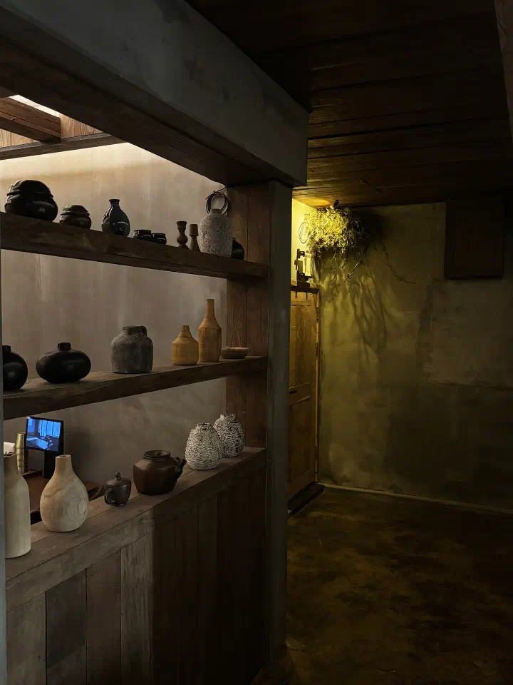 Timber display shelf of ceramic and wooden vessels along an inner passage at Apgujeong Sanghoe