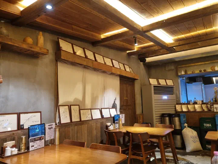 Framed celebrity signatures along the timber wall of the ground floor hall at Apgujeong Sanghoe