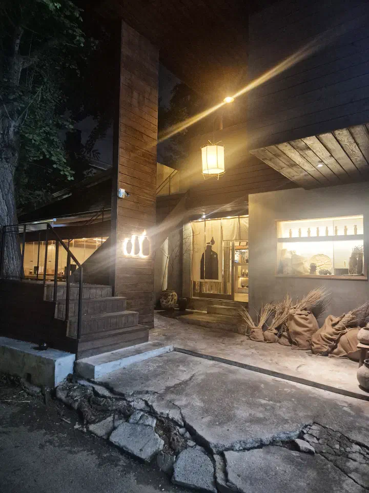 Apgujeong Sanghoe at night, its wooden entrance courtyard lit by a hanging paper lantern
