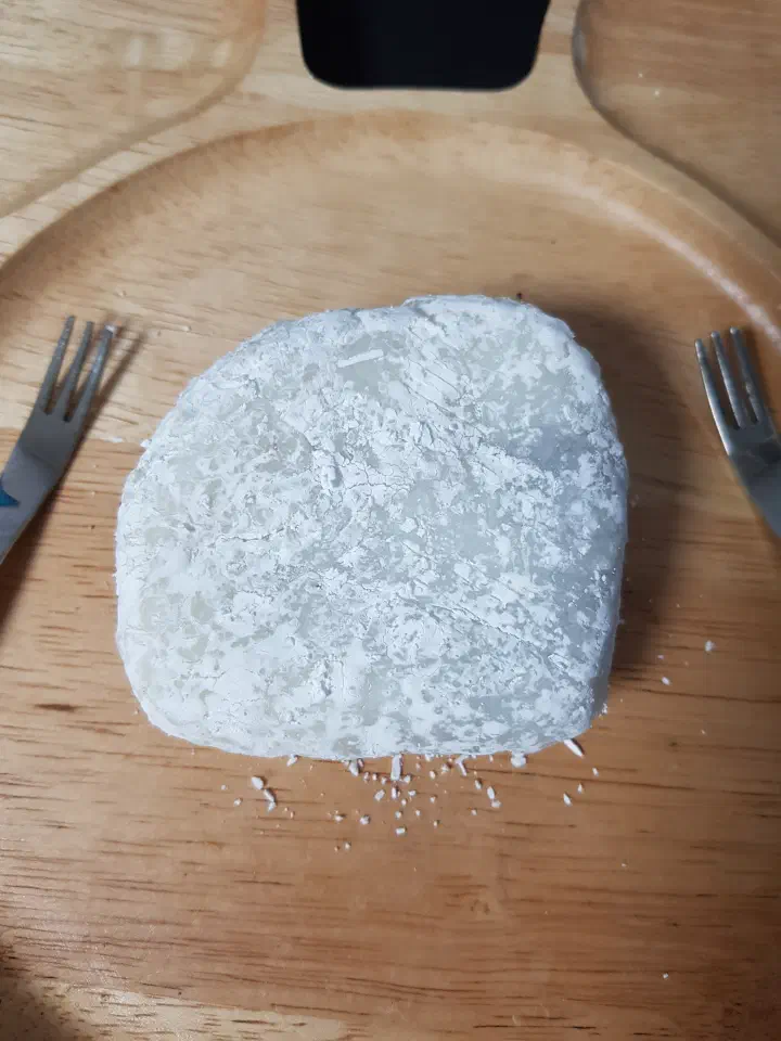 A single white chapssaltteok from Chamsoon Chaltteokbang with visible rice grains