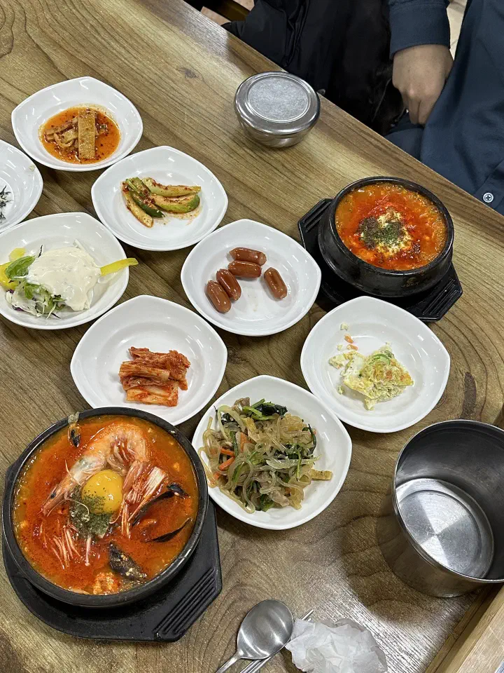 최일순짬뽕순두부 매장 나무 테이블에 순두부 두 그릇과 반찬이 가득 차려진 모습